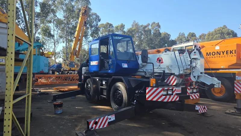 SteelBand Projects crane truck lifting a mobile crane onto a flatbed trailer